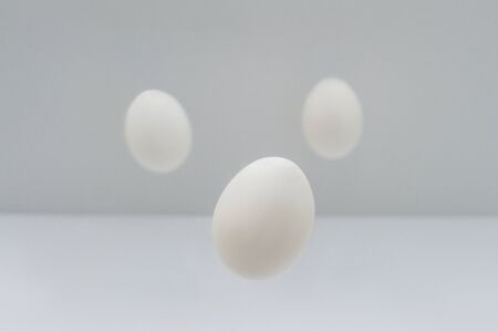 Flying three easter white eggs on light background. Minimal concept.の写真素材