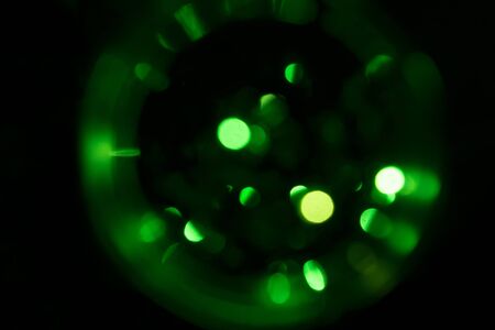 A sphere of blurred green lights on a black background. Desktop wallpaper. Space concept.の写真素材