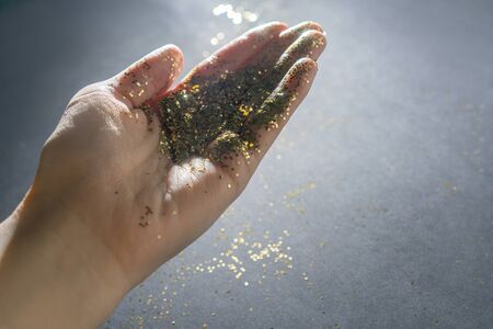The hand with shining sparkles on gray background.の写真素材