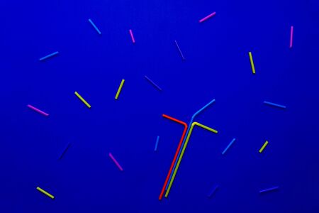 Multi-colored straws for drinking cocktail on blue background, holiday concept, top view. As firework.の写真素材