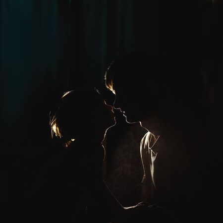 Father and son Silhouette in dark at home. Back light and spray.の写真素材