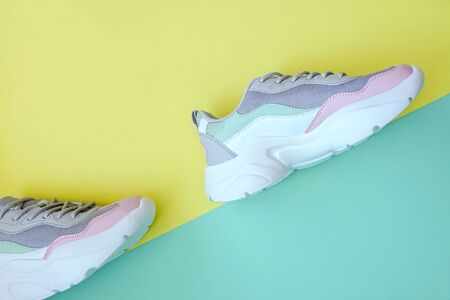 New fashion sport sneakers on dual background. Diagonal, yellow and turquoise.