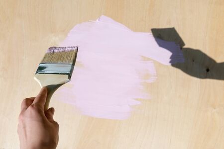 Top view on Pink paint smear with brush on wooden background.の写真素材