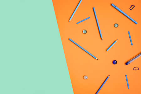 Blue stationery on orange. Flat lay. Turquoise background for text. Hipster minimal concept.