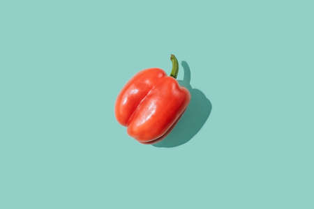 Red sweet pepper on turquoise background. Single bright vegatable.の写真素材