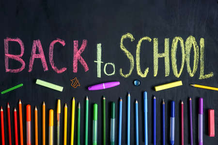 Colorful stationery on black. Flat lay. Row of tools, gradient rainbow colors. Back to school...