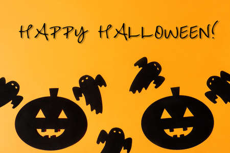 Flat lay Halloween background with decorative pumpkin and ghost on orange backdrop. Happy halloween...