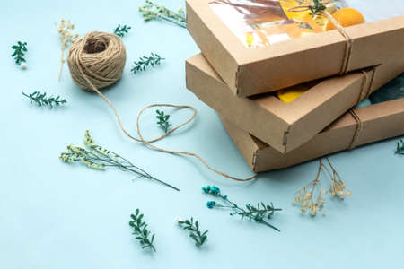 Christmas or birthday present wrapping background. Twine and gift boxes. Green little branches and...