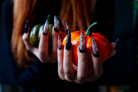 Halloween Nail Art Design, hands and pumpkins close up. Beautiful marble manicure on hands.の写真素材