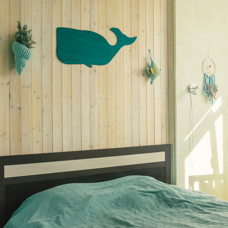 Interior of the bedroom in a marine theme with wooden wall, whale and knitted shell on wall.の写真素材