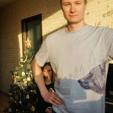 Family couple and Christmas tree. Unusual composition, man on foreground blurred, woman on...