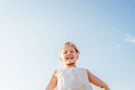 Portrait of happy smiling little girl with close eyes. Sky background. Freedom and happiness...