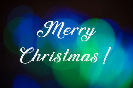 Merry christmas text on abstract blue and green lights bokeh backgroundの写真素材