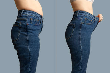 Female body before and after weight loss, diet concept. Woman is measuring waist. Belly and legs in jeans close-up.の写真素材