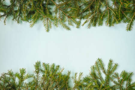 Frame from christmas garland from fir branches on blue background. Copy space.の写真素材