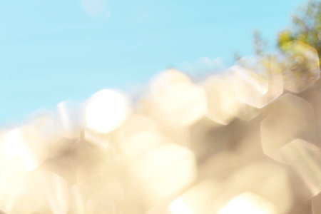 Soft lights hexagon bokeh background. Golden and blue background. Pastel colors, holidays concept.の写真素材