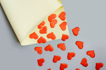 Red hearts fly from yellow package on a gray background. Copy space. Flat lay.の写真素材