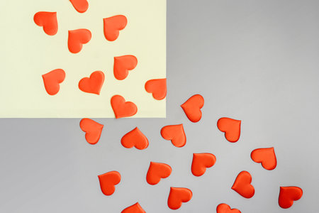 Red hearts fly from yellow square to gray background. Copy space. Flat lay. Valentines day concept.の写真素材