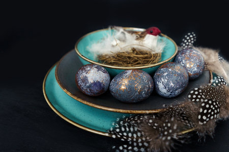 Easter concept of coloring eggs in hibiscus, eco dyes. Front view, black background and turquoise...