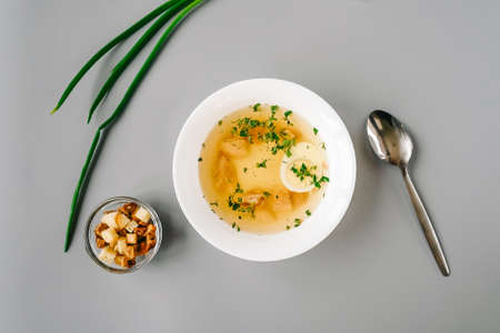 Chicken soup with vegetables in white plate.