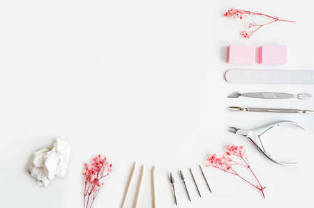 Tools of a manicure set on a white background. Pink flowers as decoration.の写真素材