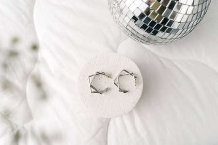 Silver modern bijouterie earrings on white background.の写真素材