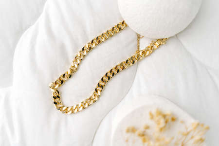 Golden modern bijouterie chain on white background.の写真素材