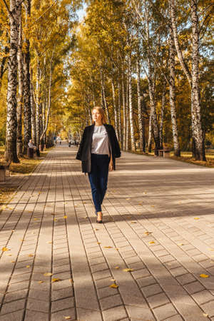 Woman walking in the autumn park. Sunny.の写真素材