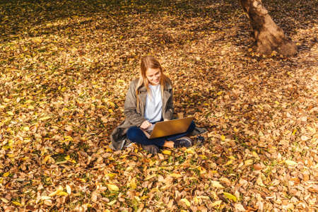 Young businesswoman working on nature with laptop.の写真素材