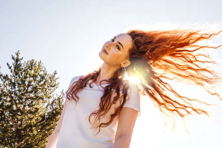 Happy woman with long hair in sunshine.の写真素材