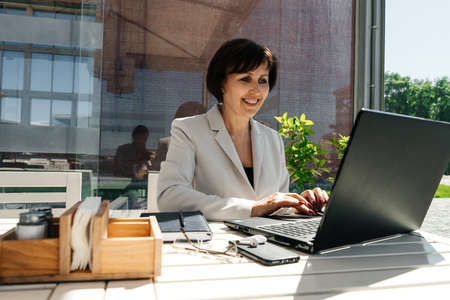 Senior businesswoman work in cafe. Remote work.の写真素材