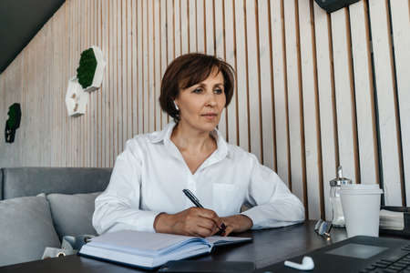 Senior businesswoman work in cafe. Remote work.の写真素材