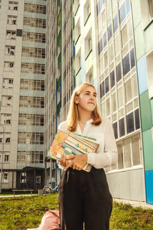 Girl stand near house with textbooks. E-learning concept.の写真素材