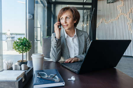Senior businesswoman work in cafe. Remote work.の写真素材