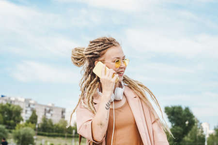 Woman with dreadlocks outdoor. Sunny summer day.