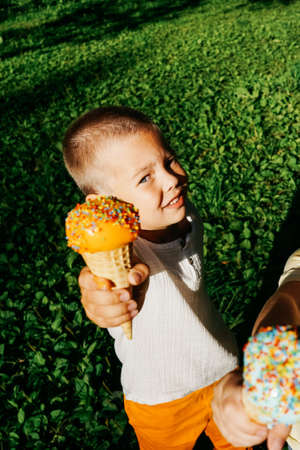 Happy boy shows ice cream on camera.