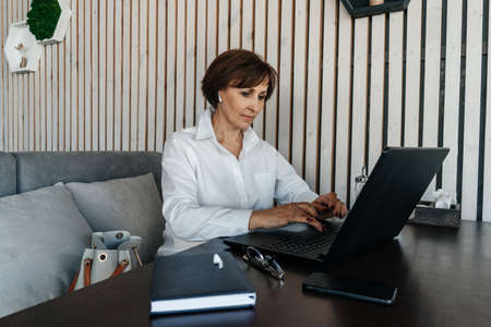 Senior businesswoman work in cafe. Remote work.の写真素材