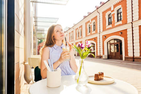 Young woman drink lemonade in summer cafe.の写真素材