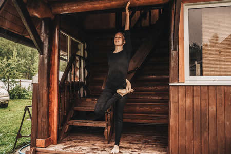 Woman doing yoga in veranda. Rainy day.の写真素材