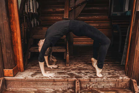 Woman doing yoga in veranda. Rainy day.の写真素材