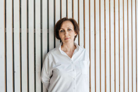 Senior businesswoman portrait on white wooden background.の写真素材