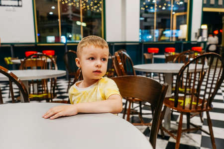 Child sitting in cafe and waiting pizza.の写真素材