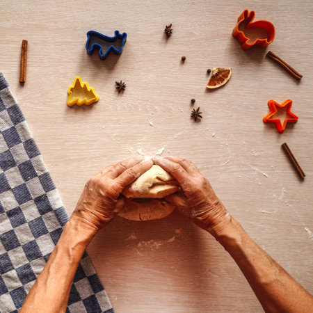 Senior hands knead the dough on table.の写真素材