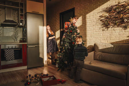Happy family decorating a Christmas tree home.の写真素材