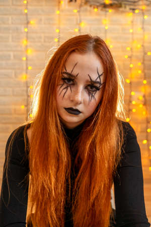 Halloween Witch woman portrait, garland on background.の写真素材