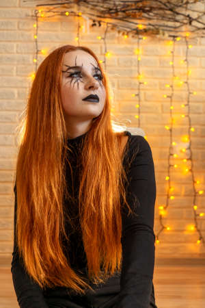 Halloween Witch woman portrait, garland on background.の写真素材