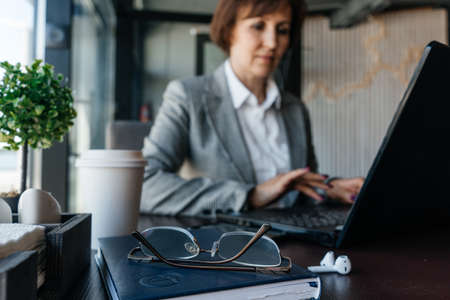 Senior businesswoman work in cafe. Remote work.の写真素材