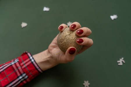 Christmas manicure. Red nails on green background.