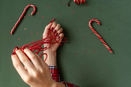 Christmas manicure. Red nails on green background.の写真素材