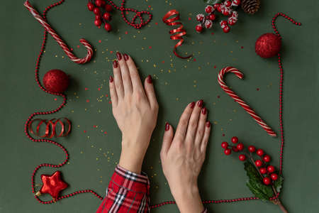Christmas manicure. Red nails on green background.の写真素材